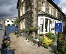 An external view on the three-star Adam Place Guest House in 1 Park Avenue Windermere, Lake District with outdoor seating 