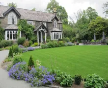 An exterior view of the five-star Cedar Manor Hotel & Restaurant  in Windermere with nicely tendered gardens.