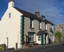 An external image of the three-star Cumberland Inn with outdoor seating  in the centre of the small town of Alston  in the North Pennines AONB