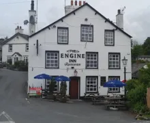 An external view of the three-star Engine Inn with outside seating and parasols in Cark