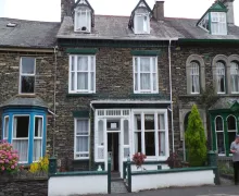 An exterior view of a traditional Lakeland stone built  property, the three star Green Gables Guest House in Windermere within the Lake District.