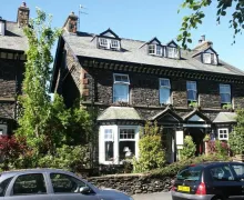 A front , exterior view of the four star Haisthorpe Guest House with a traditional Lakeland stone appearance in Windermere within the Lake District