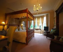 An image of a spacious bedroom and four-poster canopy bed in the four-star Hilton House Wndermere, Lake District.