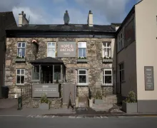 An external view of the mostly stone faced Hope and Anchor Inn with the front entrance clearly on view in Flookburgh.