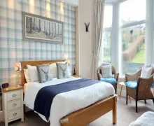 A view on a light, bright bedroom in the Invergarry Room Only Guest House For Adults with garden vies.