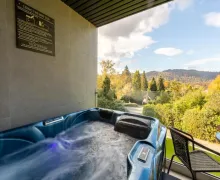 One of  number of bedrooms that have a hot tub, together with fine scenic views of trees and fells in the distance.