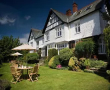 An image of four-star Lindeth Howe Country House Hotel and garden  with  a lwn and seating and well tendered planting near 