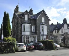 An external view of the large three-floor Lakeland stone St Johns Lodge, a four star property between Windermere and Bowness-on-Windermere in the Lake District.