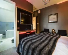 An image of a bedroom at the four-star  'The Cranleigh Boutique' Hotel in Bowness-on-Windermere with en-suite rooms.