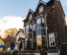 an image of the well presented 'The Royal Oak Inn' in Bowness-on-Windermere with seating and parasols on the terrace.