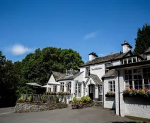 An external view of the four-star 'The Wild Boar' Inn, a white rendered traditional Inn with extensive flower boxes and other planting which make for a great impression.