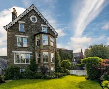 An exterior view of the five star Wheatlands Lodge Windermere with gardens in Windermere.