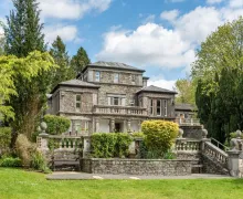 An image of the impressive three-star Windermere Manor Hotel, a large and unique Lakeland stone faced property with large gardens. 