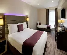 An internal view of Premier Inn Catterick Garrison Bedroom with desk and an en-suite Bathroom.