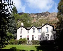 YHA Coniston Holly How with a backdrop of steeply rising fells in the Lake District